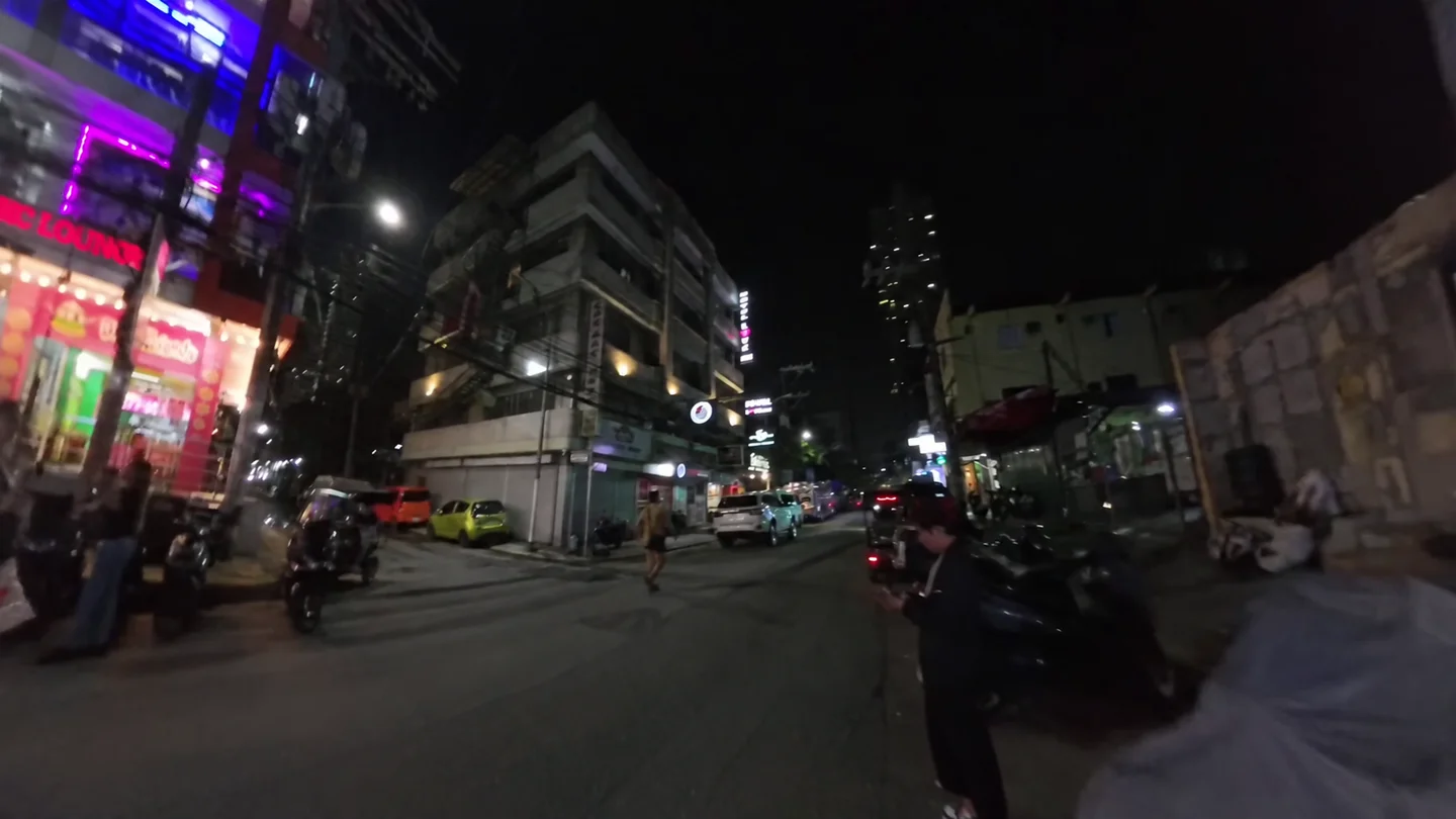 夜のマラテに並ぶ店の灯りと駐車車両